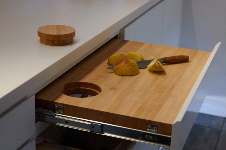 استفاده از تخته خردکن کشویی در دکوراسیون آشپزخانه کوچک که به سطح اپن یا پیشخوان آن اضافه کرده است